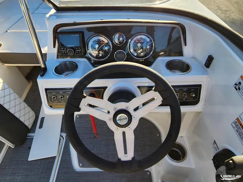 Slide: The Image of 2023 Bayliner DX2250 boat dashboard with steering wheel and control panel. - 8