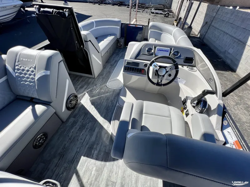 Slide: The Image of 2023 Crest Classic Platinum 220 SLS boat interior with modern seating and steering console. - 6
