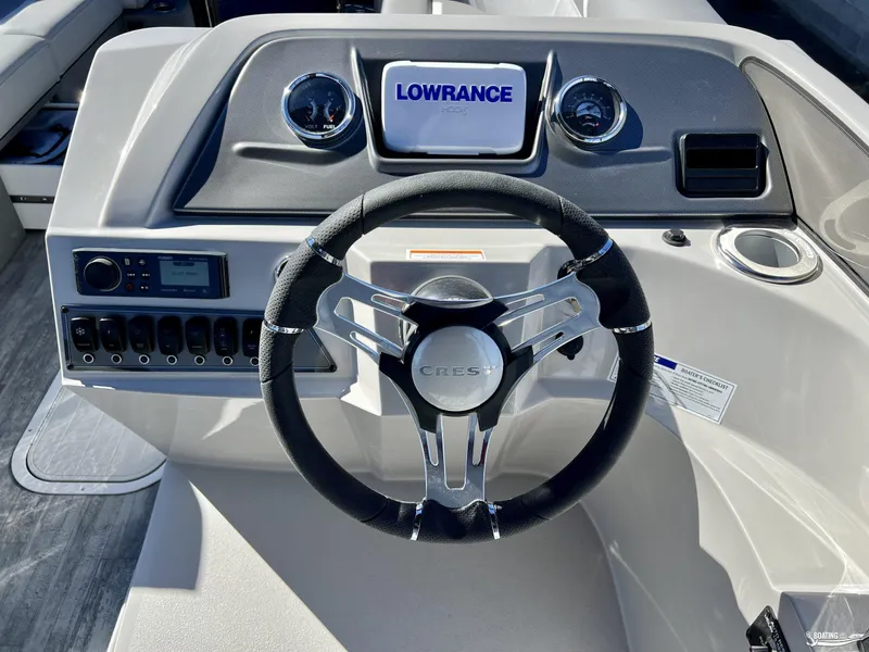 Slide: The Image of 2023 Crest Classic Platinum 220 SLS boat dashboard with steering wheel and controls. - 7