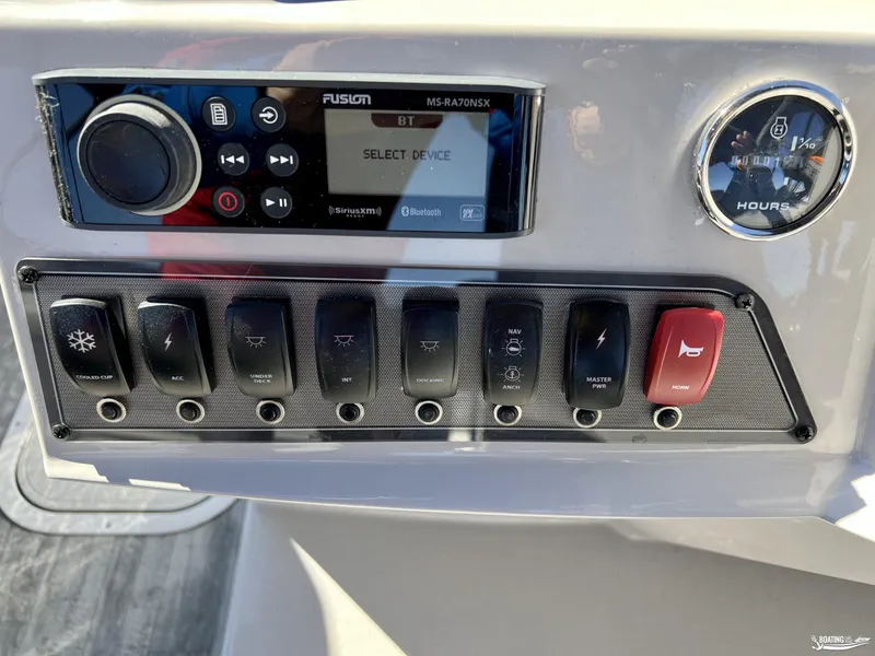 Slide: The Image of Control panel of 2023 Crest Classic Platinum 220 SLS boat with switches and display. - 8