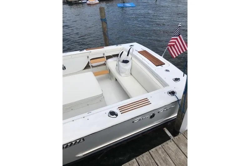 Slide: The Image of 1972 Chris-Craft Launch 23 boat docked, featuring white seating and American flag. - 11