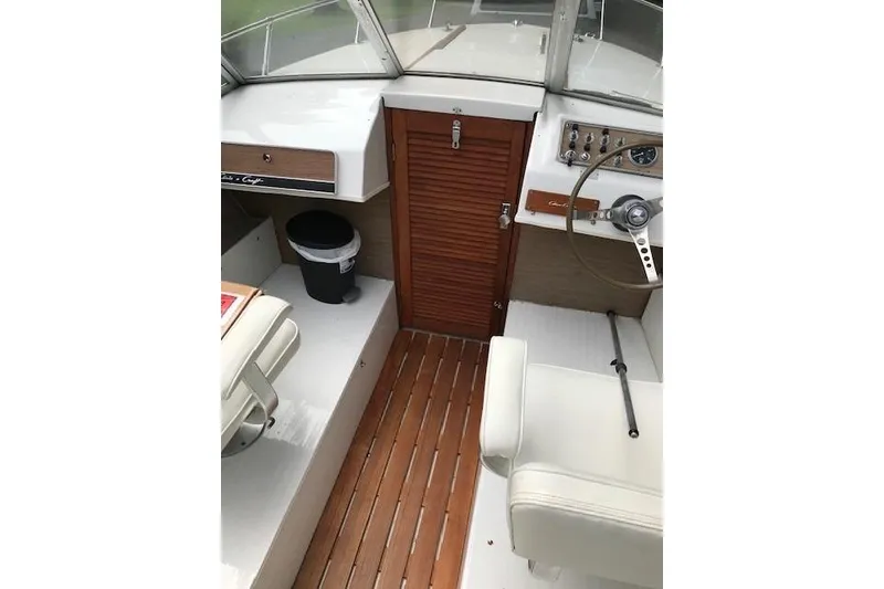 Slide: The Image of Interior of a 1972 Chris-Craft Launch 23 boat with wooden flooring and white seating. - 13