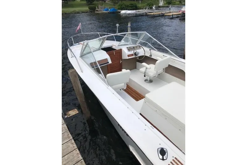Slide: The Image of 1972 Chris-Craft Launch 23 boat docked on a serene lake, showcasing classic design. - 19