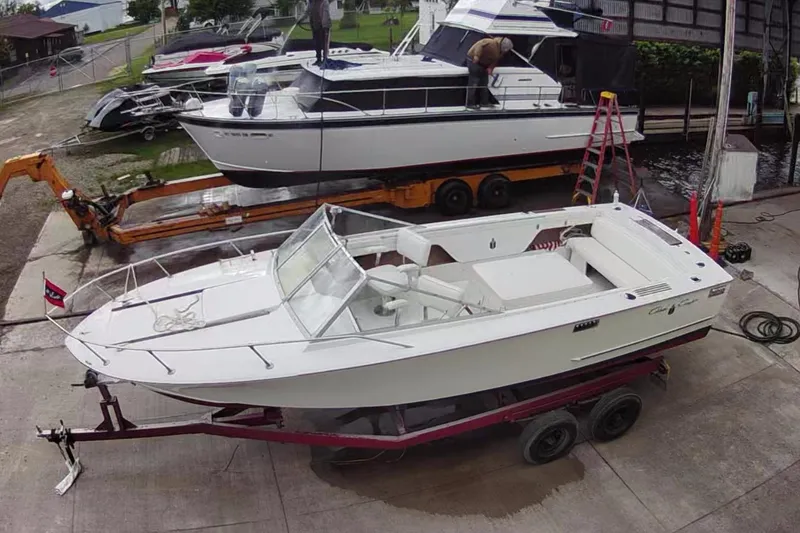 Slide: The Image of 1972 Chris-Craft Launch 23 boat on trailer, parked in a marina setting. - 3