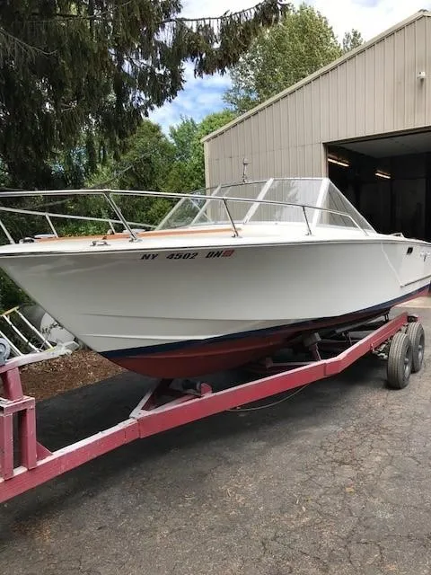 Slide: The Image of 1972 Chris-Craft Lancer boat on a trailer outside a garage. - 4