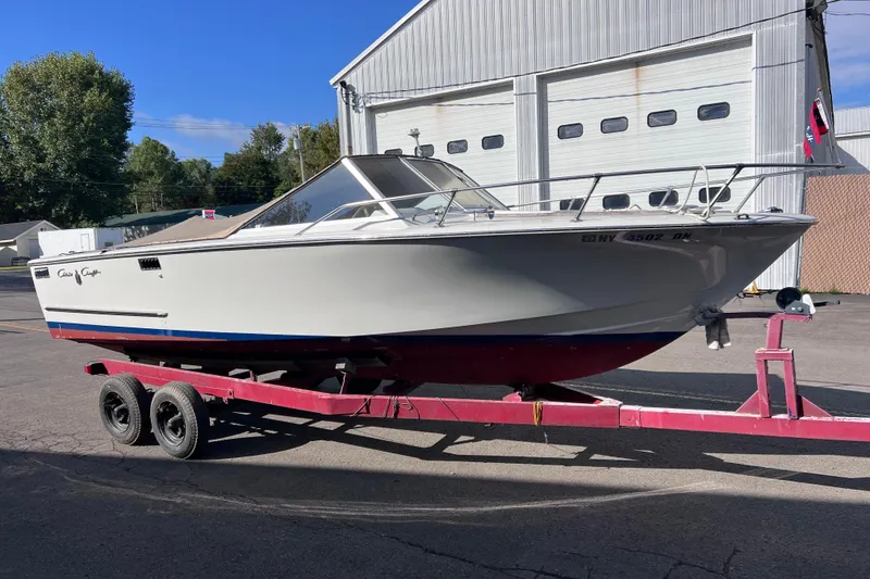 Slide: The Image of 1972 Chris-Craft Launch 23 boat on a trailer, parked outside a garage. - 6