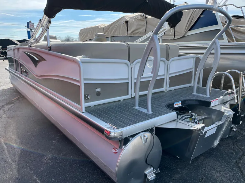 Slide: The Image of 2022 Premier 250 Solaris RF pontoon boat, rear view, docked, with seating and railing. - 13