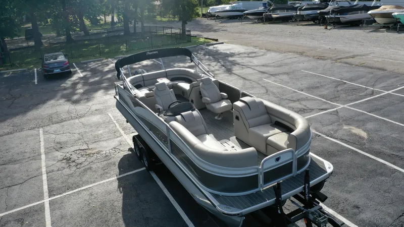 Slide: The Image of 2022 Premier 250 Solaris RF pontoon boat in a parking lot. - 2