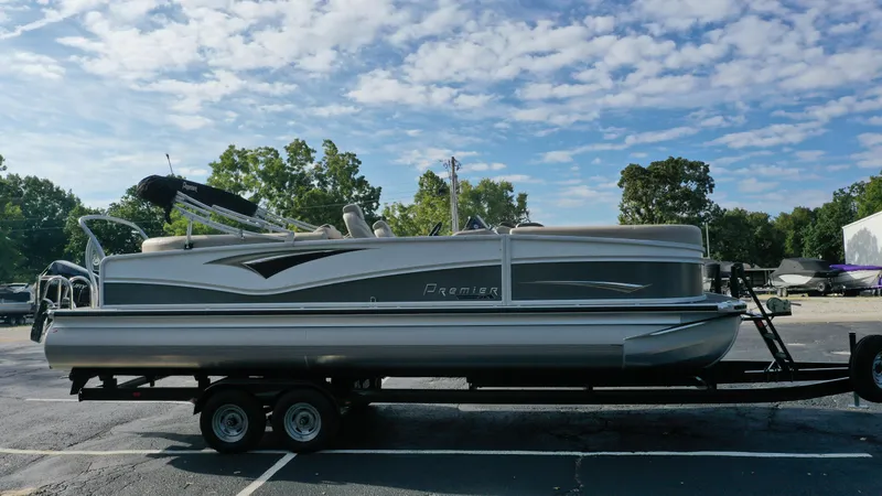 Slide: The Image of 2022 Premier 250 Solaris RF pontoon boat on a trailer under a partly cloudy sky. - 3