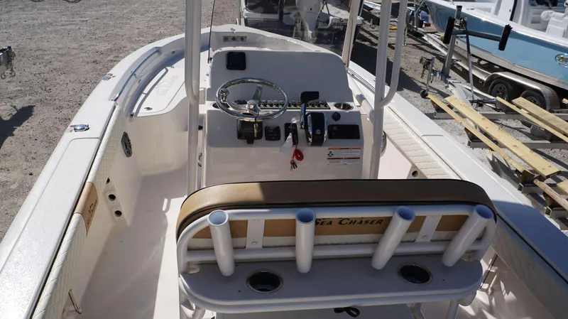 Slide: The Image of 2023 Sea Chaser 23 LX boat interior with steering console and rod holders. - 14