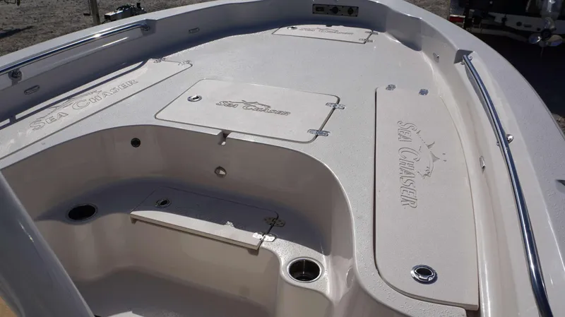 Slide: The Image of 2023 Sea Chaser 23 LX boat interior with storage compartments and stainless steel railings. - 16