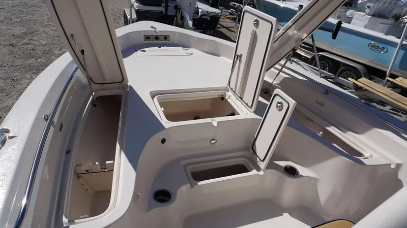 Slide: The Image of 2023 Sea Chaser 23 LX boat with open storage compartments and clean deck. - 5