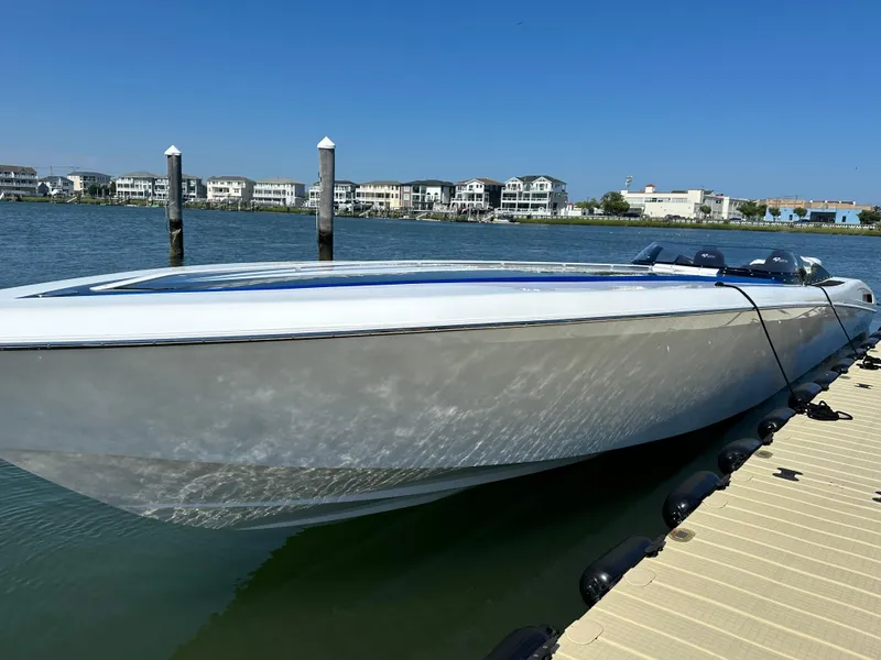 Slide: The Image of 2003 Outerlimits 47 GTX speedboat docked by waterfront homes. - 18