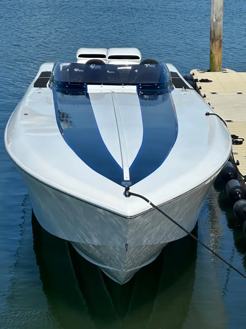 Slide: The Image of 2003 Outerlimits 47 GTX speedboat docked on calm water. - 19