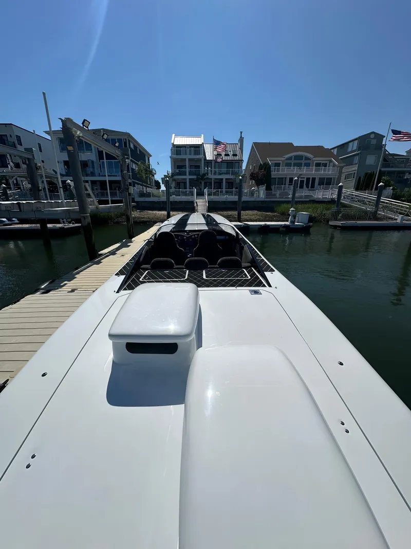 Slide: The Image of 2003 Outerlimits 47 GTX boat docked at marina with waterfront homes in background. - 20