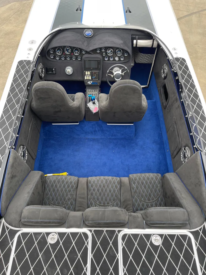 Slide: The Image of 2003 Outerlimits 47 GTX boat interior with blue carpet and black diamond-patterned seating. - 28