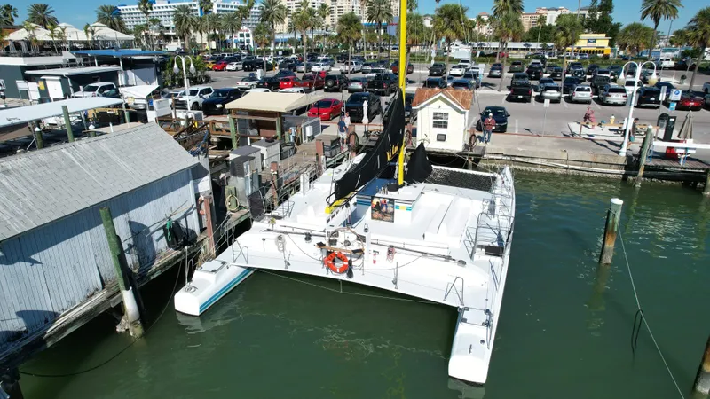 Slide: The Image of 1992 Robertson Custom Catamaran/Sloop Rig docked at a marina with nearby parking lot. - 11