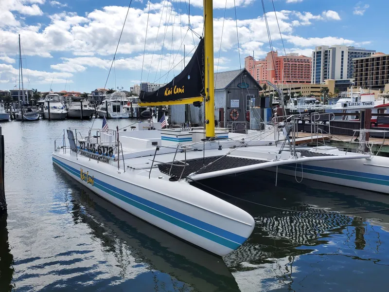 Slide: The Image of 1992 Robertson Custom Catamaran Sloop Rig docked at marina, clear sky, waterfront buildings. - 13