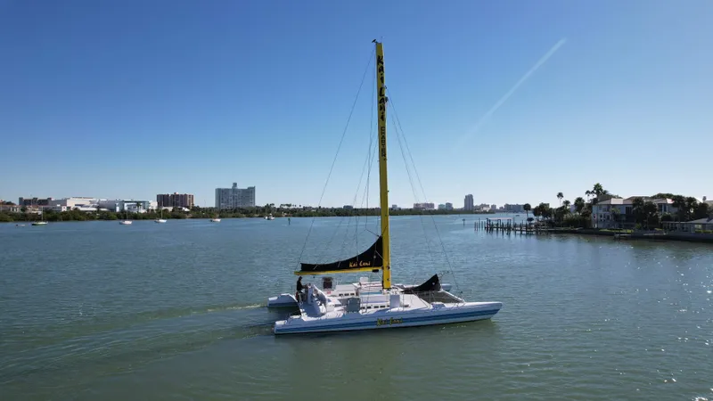 Slide: The Image of 1992 Robertson Custom Catamaran Sloop Rig sailing in a calm bay with cityscape background. - 14