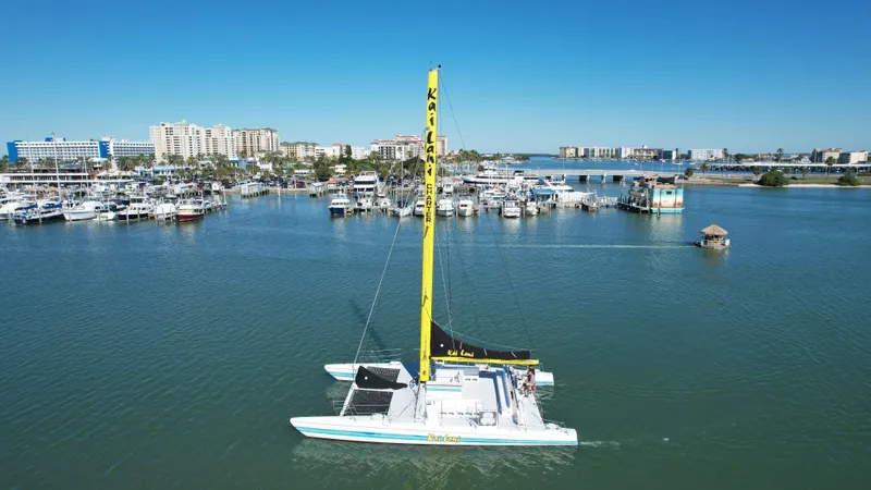 Slide: The Image of Robertson Custom Catamaran Sloop Rig 1992 sailing in a marina with cityscape background. - 15