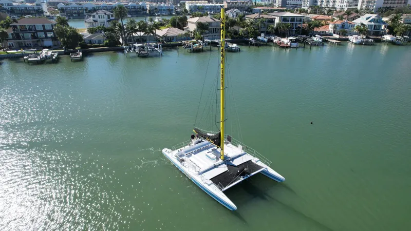Slide: The Image of Aerial view of a 1992 Robertson Custom Catamaran Sloop Rig sailing near waterfront homes. - 18