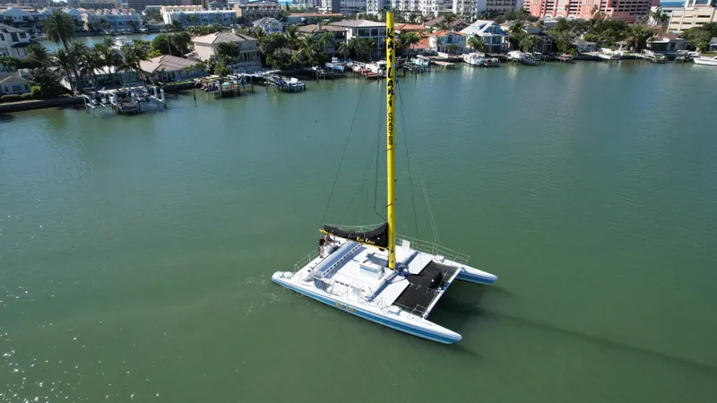 Slide: The Image of Aerial view of a 1992 Robertson Custom Catamaran Sloop Rig sailing near waterfront homes. - 21
