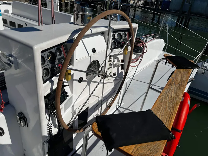 Slide: The Image of 1992 Robertson Custom Catamaran Sloop Rig helm with wooden wheel and control panel. - 23