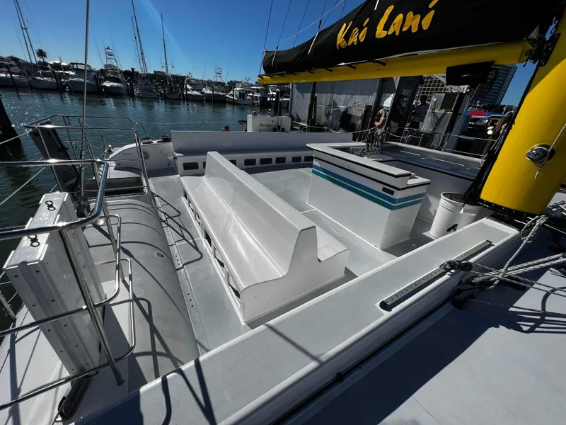 Slide: The Image of 1992 Robertson Custom Catamaran Sloop Rig docked at marina, featuring spacious deck and seating area. - 30