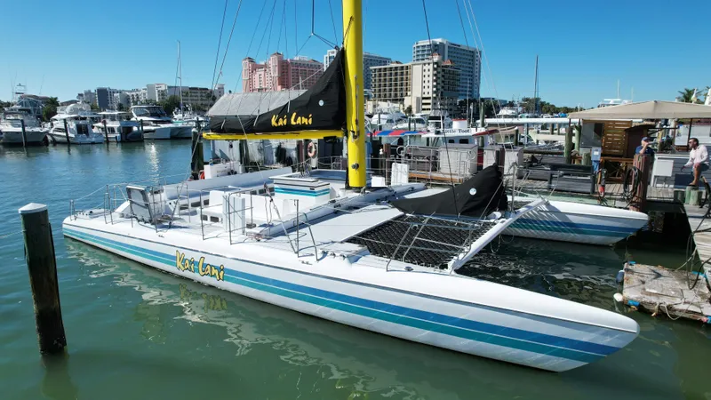 Slide: The Image of Robertson Custom Catamaran Sloop Rig 1992 docked at marina with cityscape background. - 5