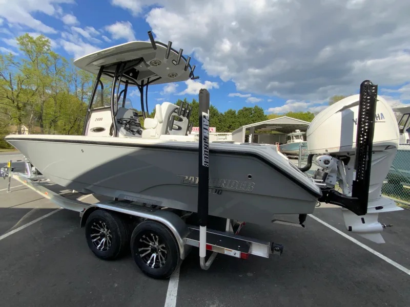 Slide: The Image of 2024 Pathfinder 2400 Open boat on a trailer, parked outdoors under a partly cloudy sky. - 8