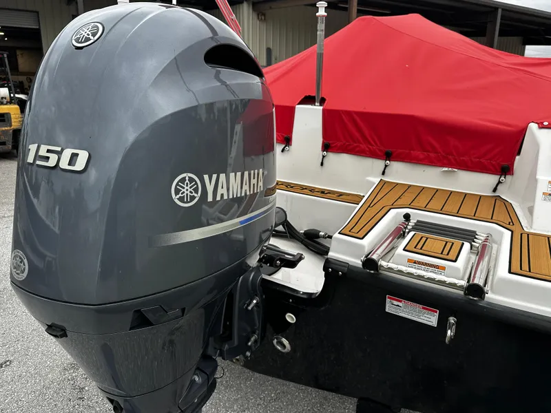 Slide: The Image of 2023 Starcraft SVX OB 191 with Yamaha 150 outboard motor, red cover, and wood accents. - 1