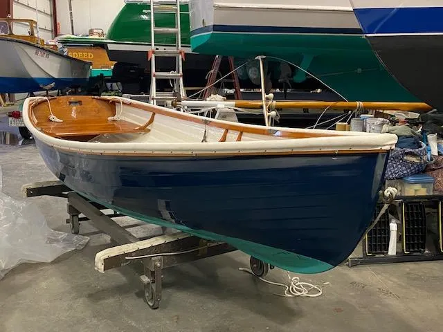 The Image of 1973 Stanley Herreshoff Yacht Tender in a workshop, blue hull, wooden interior. - 0