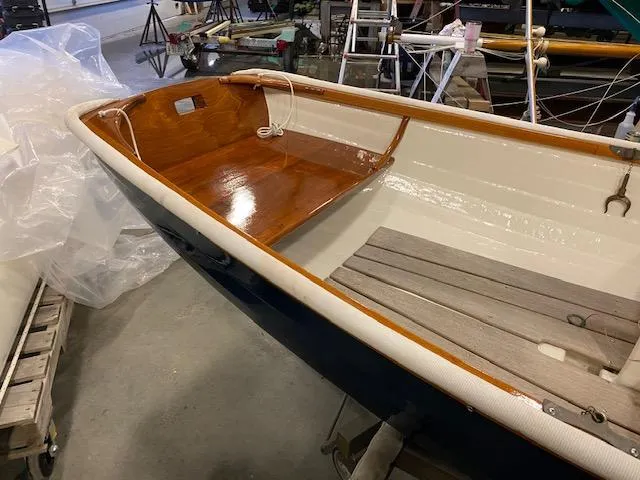 Slide: The Image of 1973 Stanley Herreshoff Yacht Tender with wooden interior, displayed indoors. - 10