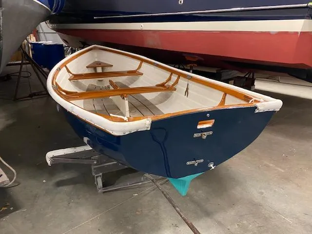 Slide: The Image of 1973 Stanley Herreshoff Yacht Tender with wooden interior, displayed indoors on a stand. - 4