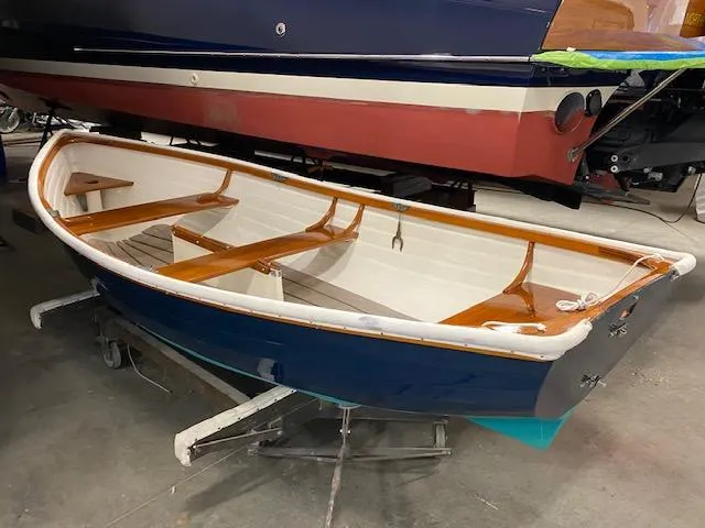Slide: The Image of 1973 Stanley Herreshoff Yacht Tender with wooden interior, displayed indoors on a stand. - 5