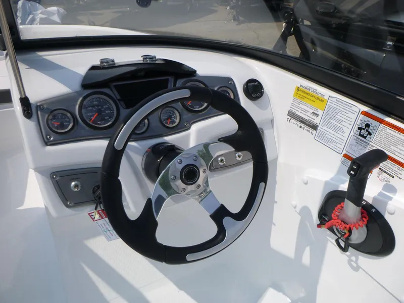 Slide: The Image of 2023 Tahoe 200 S boat dashboard with steering wheel and control panel. - 7