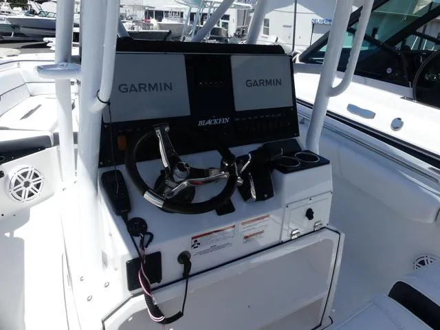 Slide: The Image of 2022 Blackfin 252CC boat console with Garmin navigation displays and steering wheel. - 16