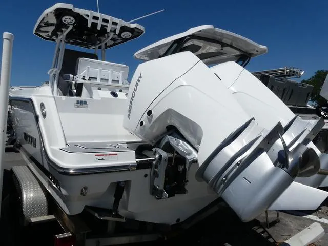 Slide: The Image of 2022 Blackfin 252CC boat with dual Mercury outboard engines, docked on a trailer. - 4