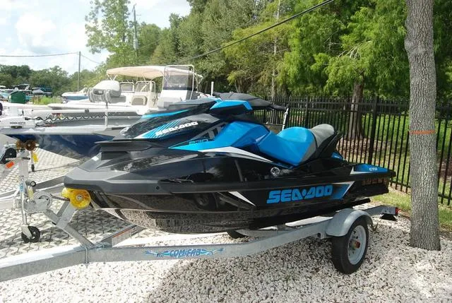 Slide: The Image of 2018 Sea-Doo Waverunner GTR on trailer, black and blue, parked outdoors. - 1