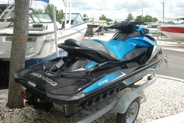 Slide: The Image of 2018 Sea-Doo Waverunner GTR on a trailer at a marina. - 2