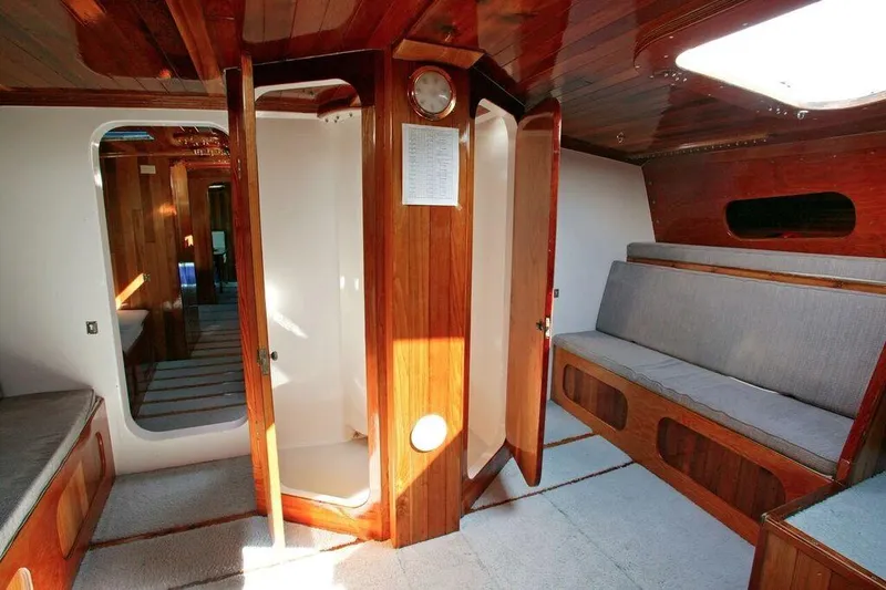 Slide: The Image of Interior of a 1996 Custom 100' Sailing Yacht with wooden finishes and seating area. - 10