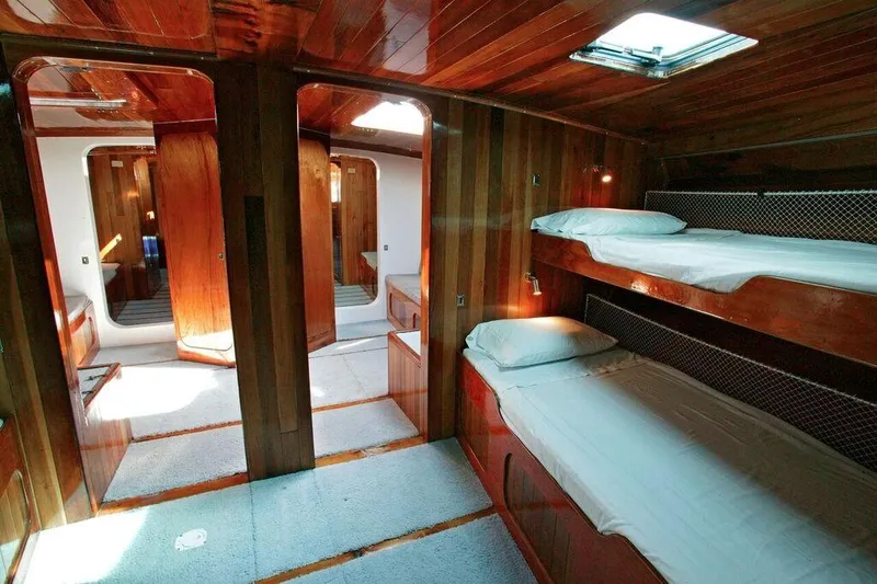 Slide: The Image of Interior of a 1996 custom 100' sailing yacht with wooden bunk beds and polished wood finish. - 11
