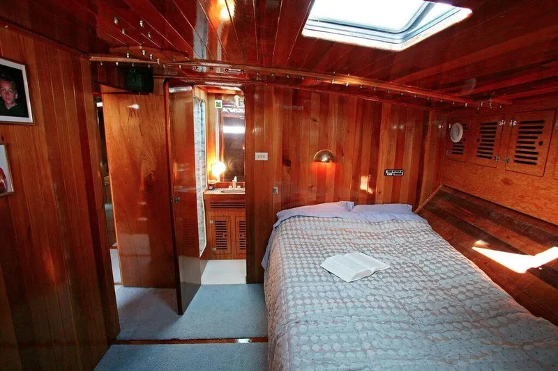 Slide: The Image of Luxurious wooden cabin interior of a 1996 Custom 100' Sailing Yacht with skylight and cozy bed. - 14