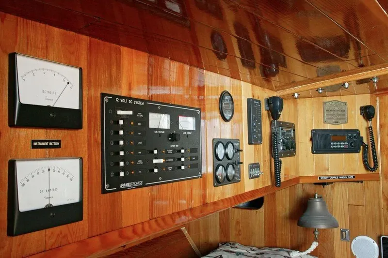 Slide: The Image of Control panel of a 1996 Custom 100' Sailing Yacht with gauges and communication devices. - 25