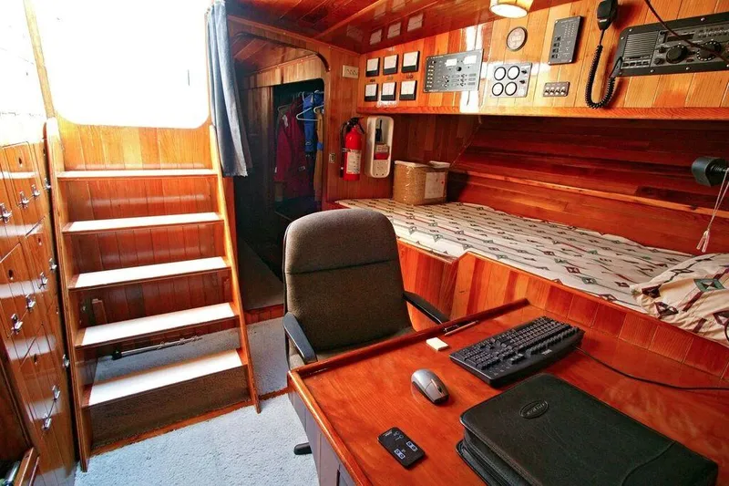Slide: The Image of Interior of a 1996 Custom 100' Sailing Yacht with wooden paneling and navigation equipment. - 26