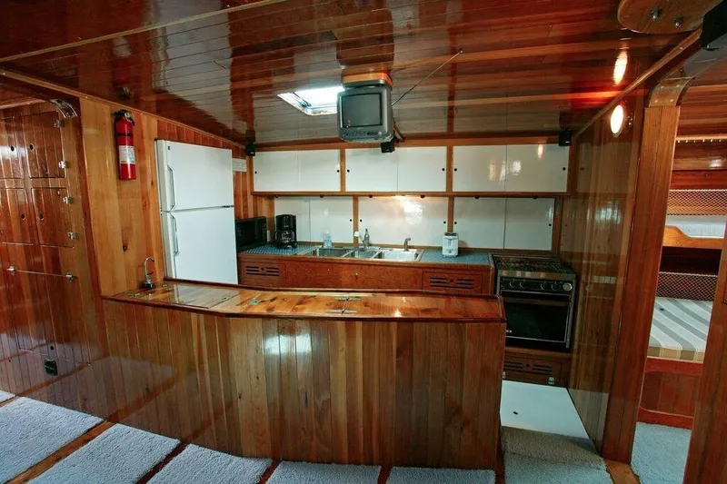 Slide: The Image of 1996 Custom 100' Sailing Yacht kitchen with wooden cabinetry and modern appliances. - 4