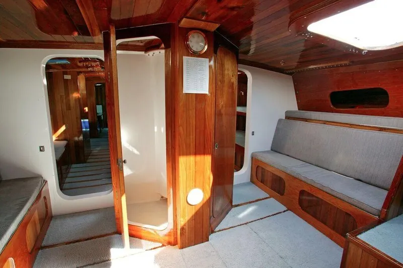 Slide: The Image of Interior of a 1996 Custom 100' Sailing Yacht with wooden finishes and seating area. - 7