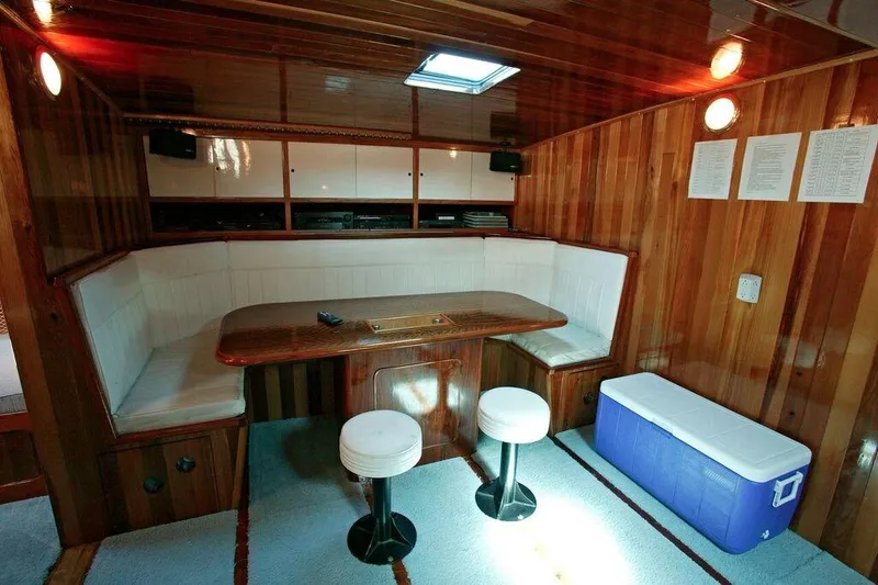 Slide: The Image of Luxurious wooden interior of a 1996 Custom 100' Sailing Yacht with white seating and a table. - 8