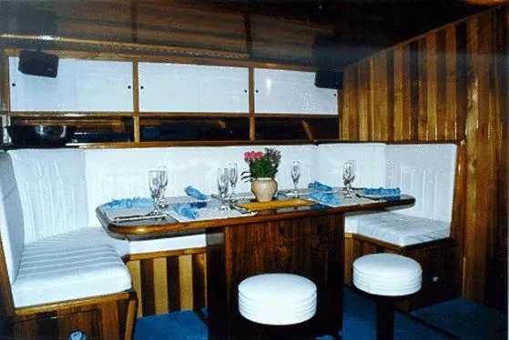 Slide: The Image of Luxurious dining area inside a 1996 Custom 100' Sailing Yacht with elegant wooden finishes. - 9