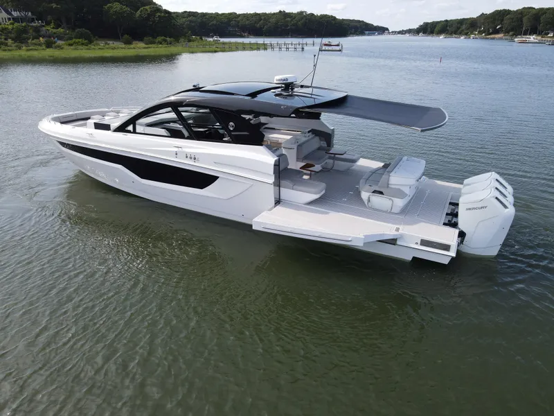 Slide: The Image of 2025 Cruisers Yachts 50 GLS Outboard luxury boat on a serene lake. - 21